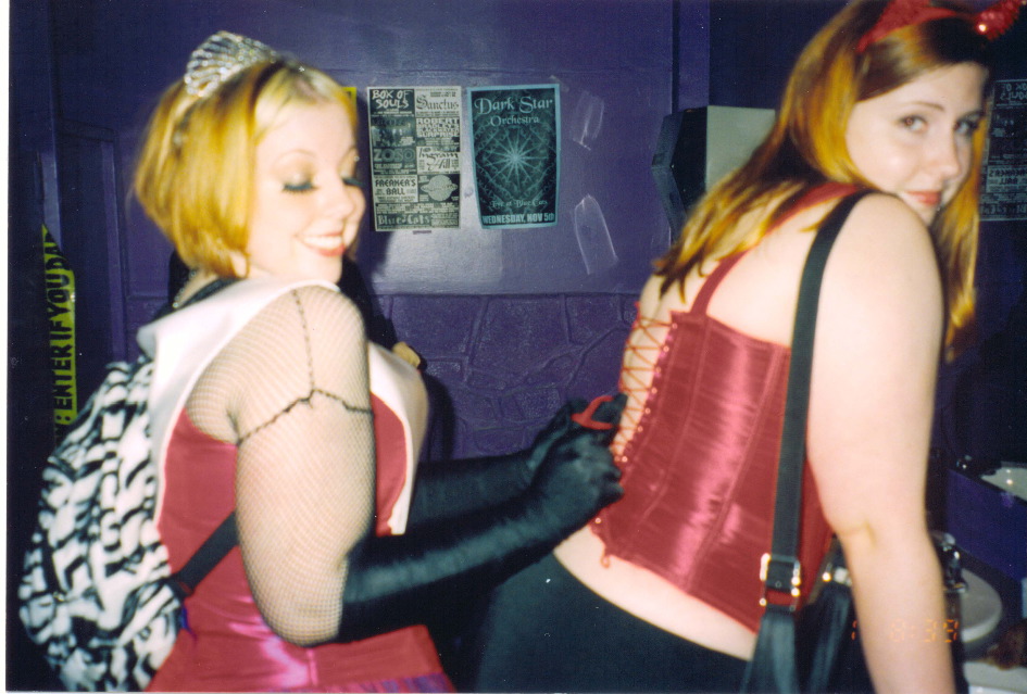 Gwenhwyfar getting her corset tied in the bathroom
